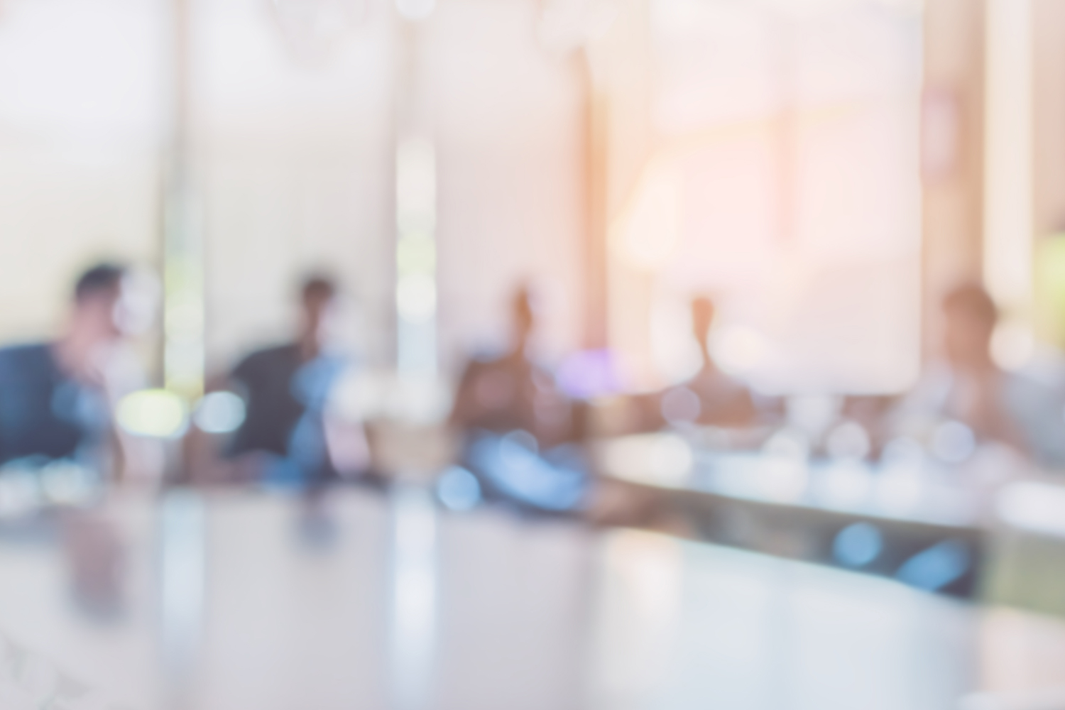 Blurry image of people sitting in a conference room