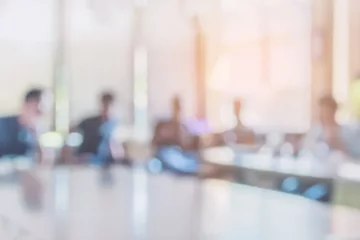 Blurry image of people sitting in a conference room