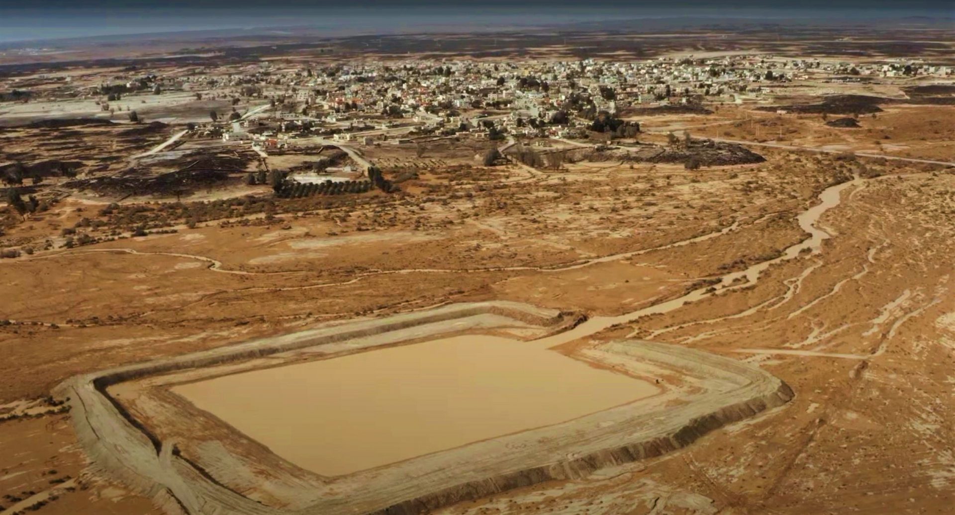 A new water harvesting structure in Azraq water basin of Jordan, made from surrounding mud, is seamlessly integrated into its environment.