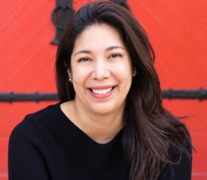 A woman smiling with a red background