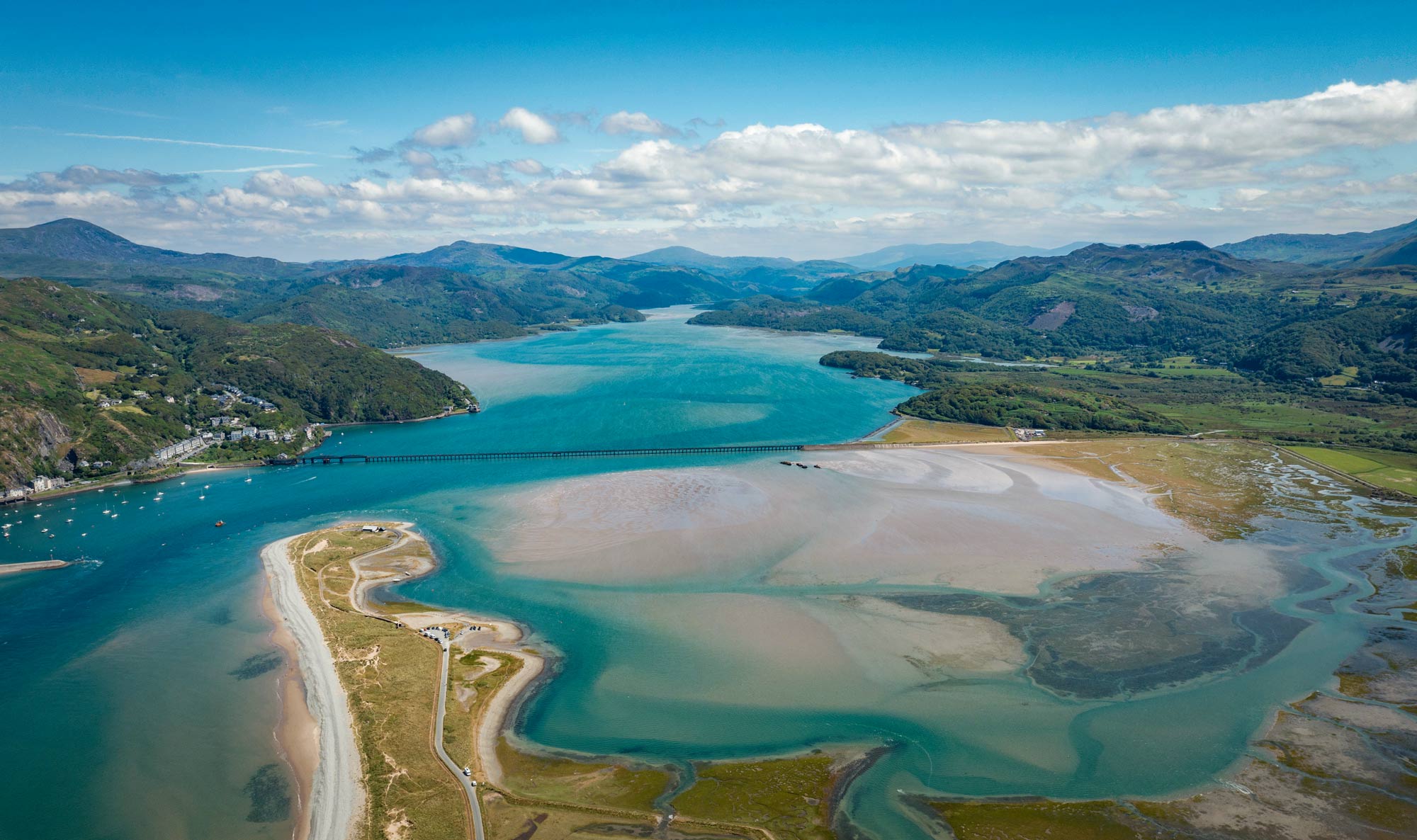 Aerial view of a coastal estuary, with mountains in the background