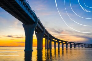 Road bridge crossing a clam body of water at sunset