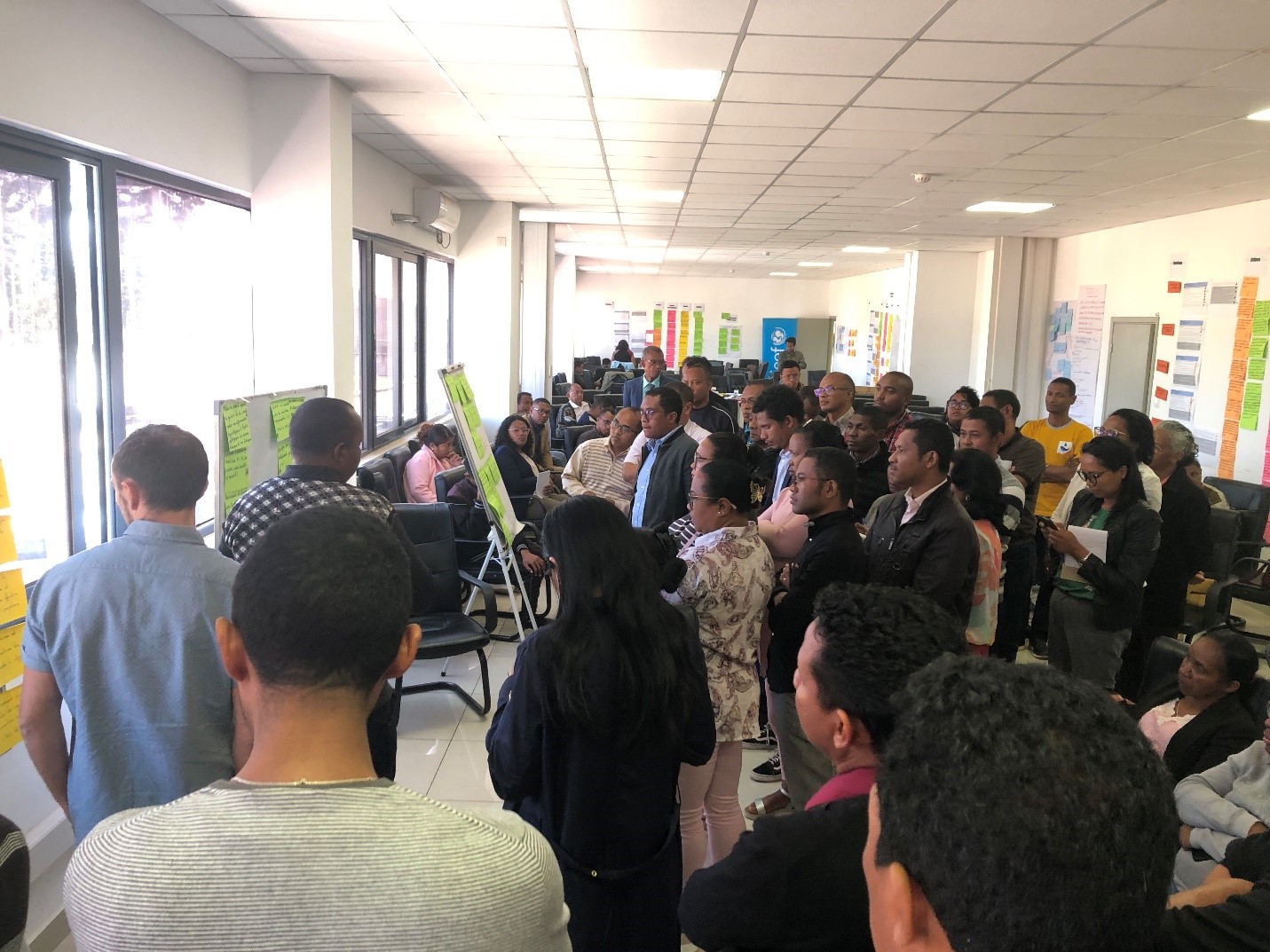 Group of participants gather and look over a paper diagram