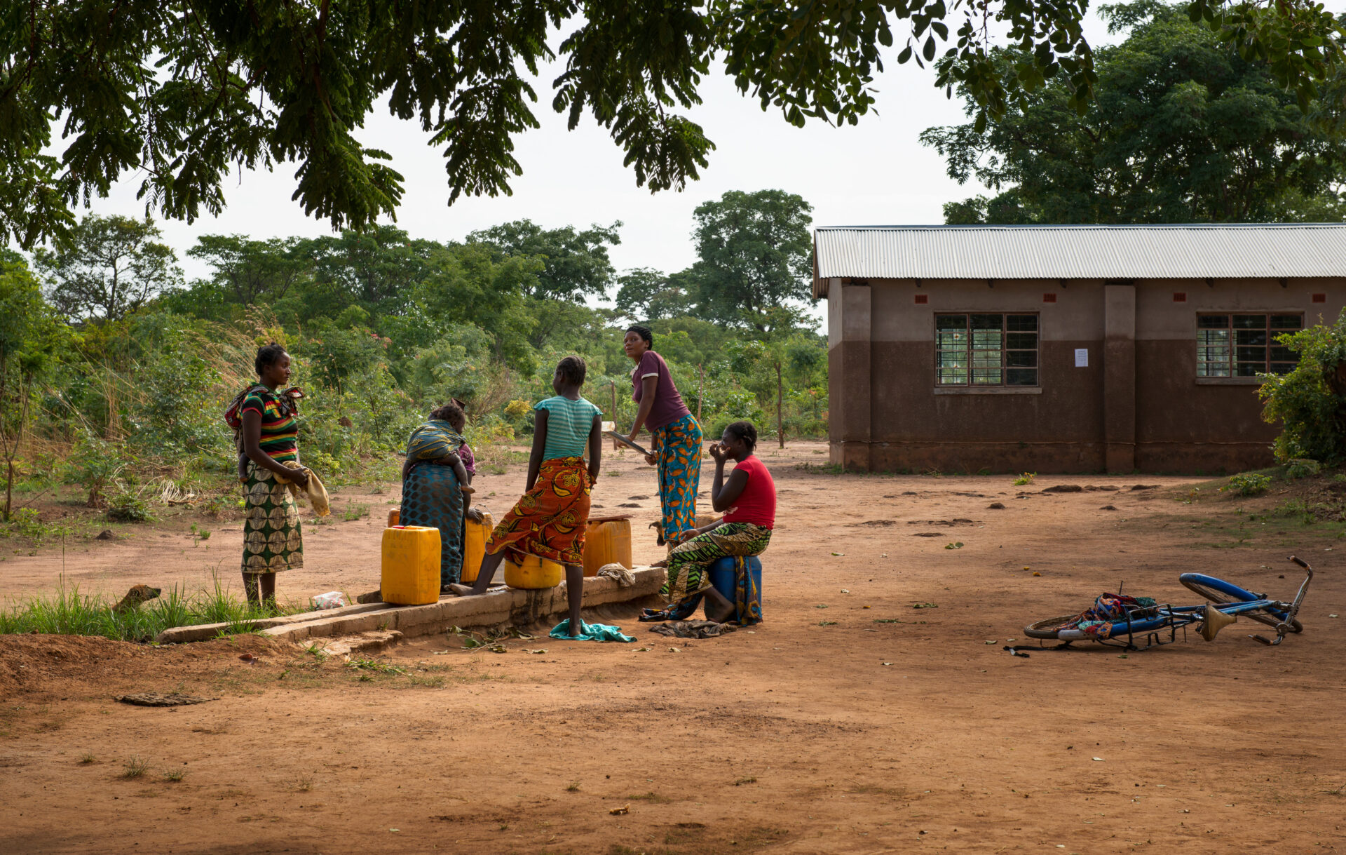 5 women fetching water in a rural area